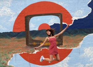 mother holds toddler painting on a canvas at the Laramie Plains Civic Center Artist Sunday event in Laramie, WY